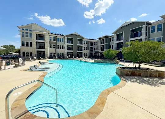 A swimming pool in front of apartment buildings.