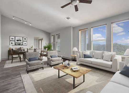A living room with a white couch, a coffee table, and a ceiling fan.