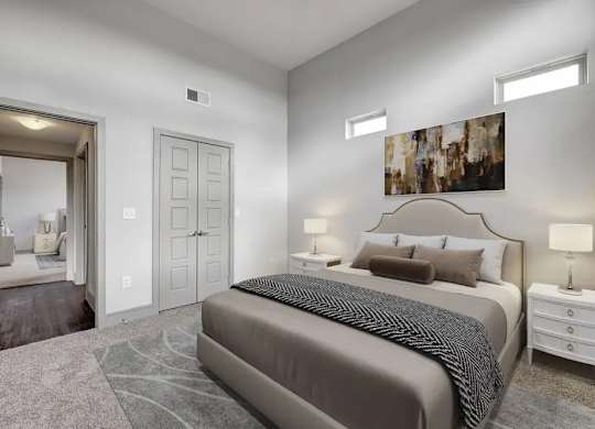 A bedroom with a large bed and a painting on the wall.