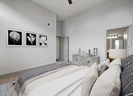 Three framed pictures hang on a white wall above a bed.