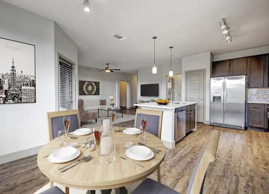 A dining room with a wooden table set for two.