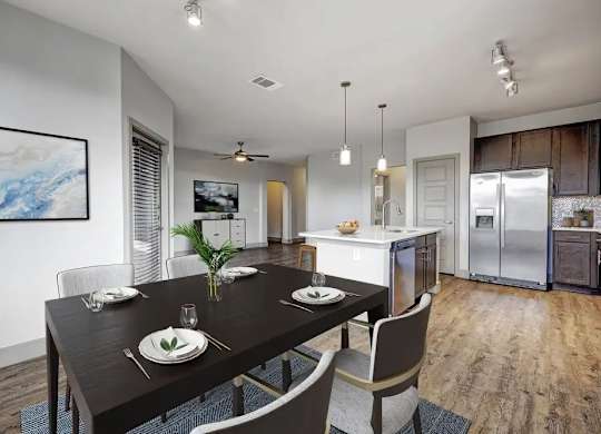 A modern dining room with a wooden table set for two.