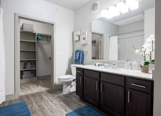 A bathroom with a toilet, sink, and a cabinet.
