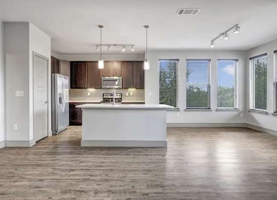A modern kitchen with a large island and wooden floors.
