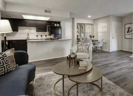 A modern living room with a fireplace and a dining area in the background.