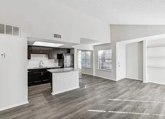 A kitchen with white cabinets and a black countertop.