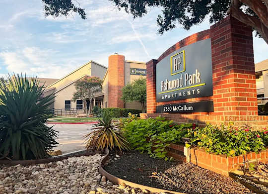 The front of Ashwood Park Apartments is shown with a sign and landscaping.