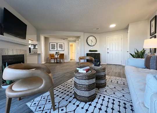 A living room with a fireplace, a chair, a couch, and a rug.