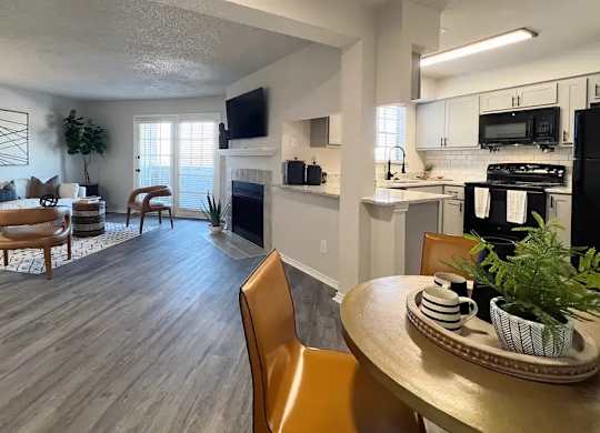 A modern living room with a fireplace and a dining table set for two.