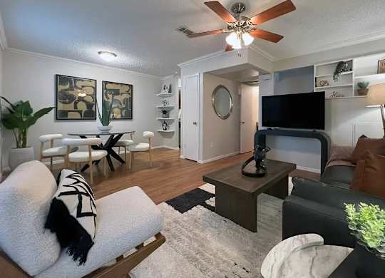 A living room with a white couch and a black and white striped pillow.