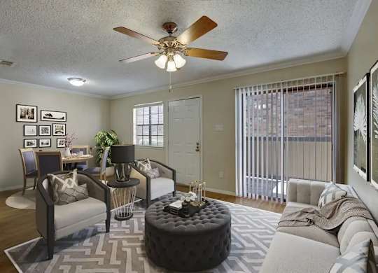 A living room with a couch, chair, and a table with a vase of flowers on it.