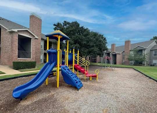 A playground with a blue slide and a yellow and red slide.