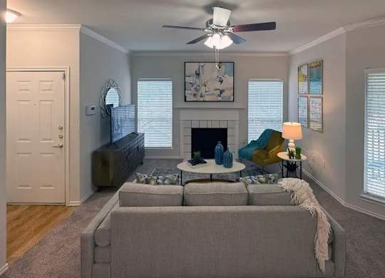 A living room with a grey couch and a fireplace.