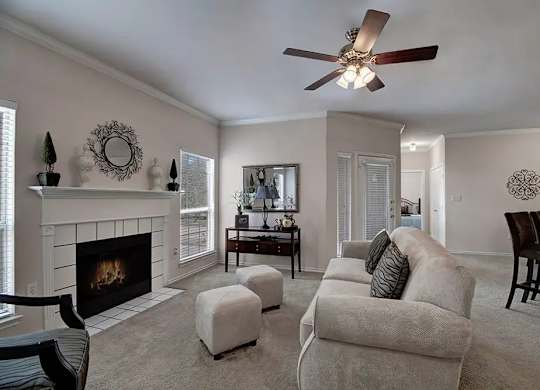 A living room with a fireplace and a ceiling fan.