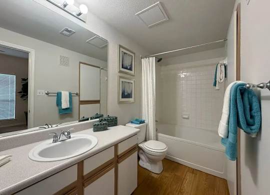 A bathroom with a white sink, toilet, and bathtub.