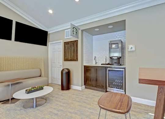 A living room with a sofa, a table, a chair, and a television.