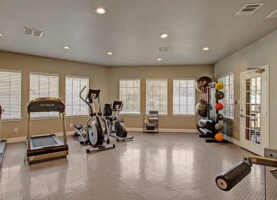 A spacious home gym with treadmills, elliptical machines, and other exercise equipment.