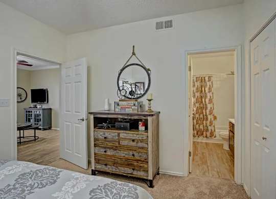 A bedroom with a bed, a dresser, and a mirror.