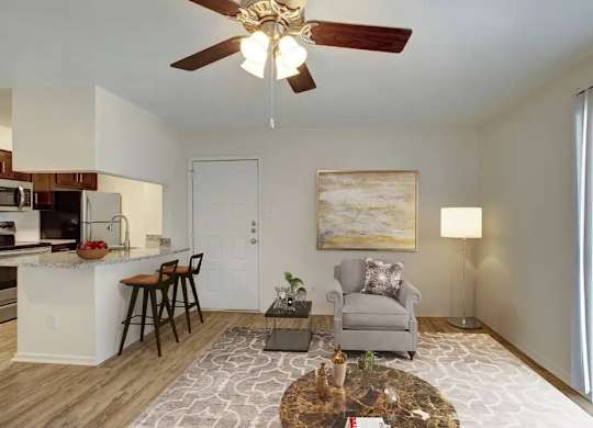 A living room with a grey couch, a coffee table, and a painting on the wall.