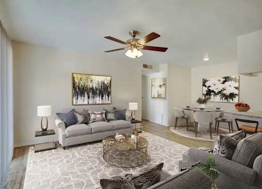 A living room with a grey couch, a coffee table, and a painting on the wall.