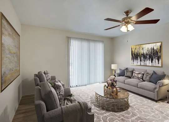 A living room with a grey couch, a coffee table, and a ceiling fan.