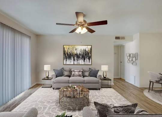 A living room with a grey couch, a coffee table, and a painting on the wall.