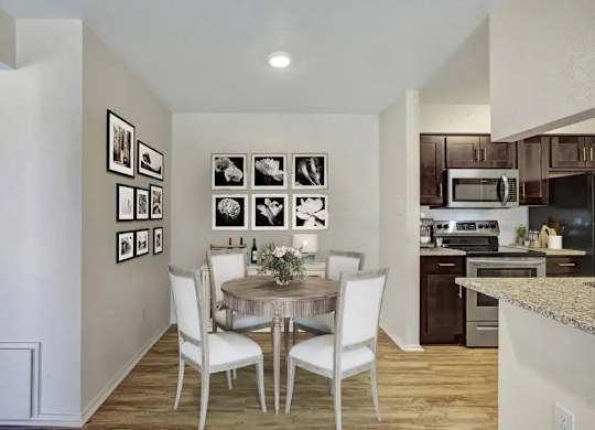 A kitchen with a table and chairs in the middle of the room.