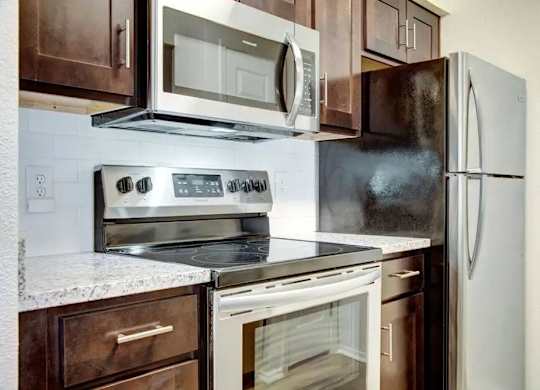 A kitchen with a white refrigerator, stove, and oven.