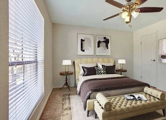 A bedroom with a bed, a bench, and a ceiling fan.