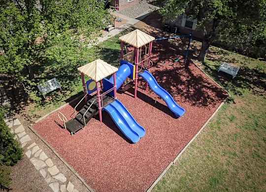 A playground with a blue slide and a yellow canopy.
