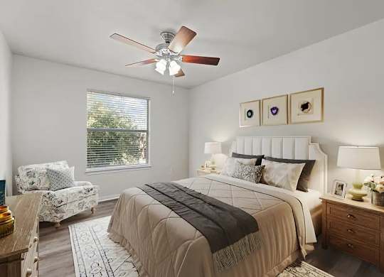 A bedroom with a large bed and a ceiling fan.