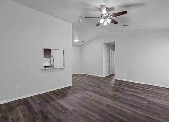 A room with a ceiling fan and a mirror on the wall.
