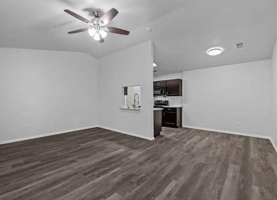 A room with a ceiling fan and wooden flooring.