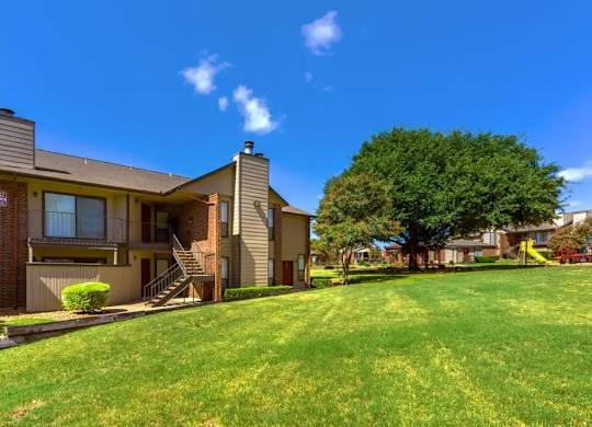 A sunny day at a grassy apartment complex.