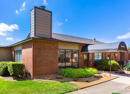 A house with a brick chimney and a black roof.