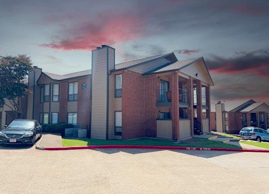 A modern apartment building with a parking lot in front.