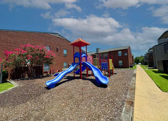 Colorful playground with slides and climbing features at South Meadows Apartments, Red Oak, TX
