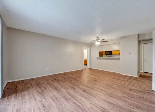 Spacious living room with wood style flooring at South Meadows Apartments, Red Oak, Texas