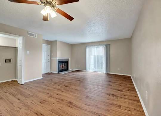 Empty living room with fireplace and vaulted ceiling at South Meadows Apartments, Texas, 75154