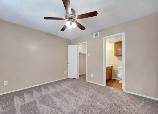 Bedroom with walk-in closet and private bathroom at South Meadows Apartments, Red Oak, Texas