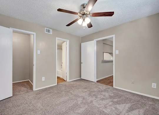 Bedroom with multiple closets and bathroom access at South Meadows Apartments, Red Oak
