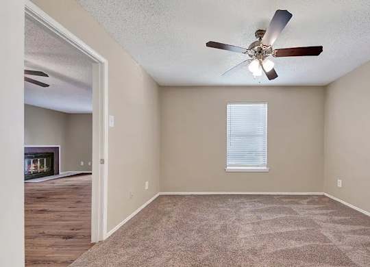Carpeted bedroom with window blinds and ceiling fan at South Meadows Apartments, Red Oak, TX 75154