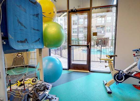 Gym with a blue mat and a variety of equipment including a treadmill at Civic at Frisco Square Apartments, Frisco, TX, 75034