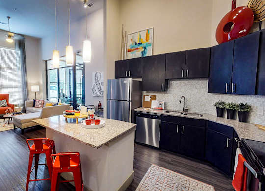 Kitchen with a white countertop and black cabinets at Civic at Frisco Square Apartments, Texas