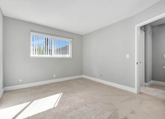 A room with a window and carpeted floor.