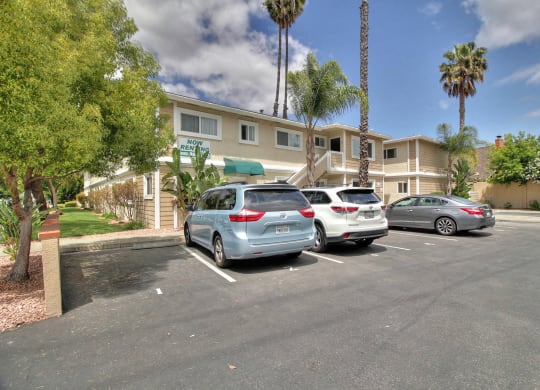 three cars parked in a parking lot in front of a building