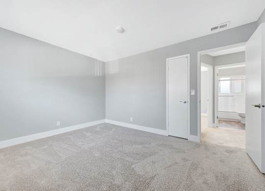 A spacious room with grey walls and carpeted floor.
