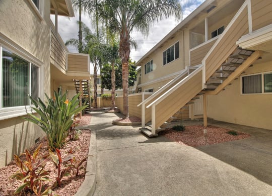 a building with stairs and palm trees in front of it