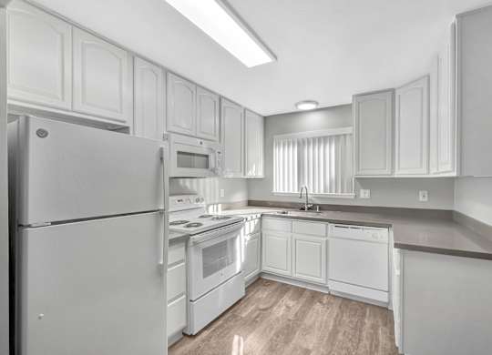 A modern kitchen with white appliances and cabinets.