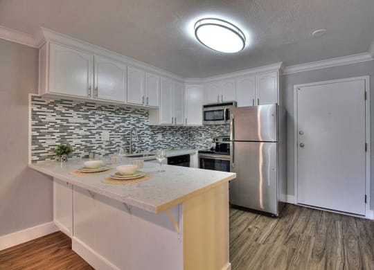 Kitchen with appliances and counter table at The Luxe, Santa Clara, CA, 95051
